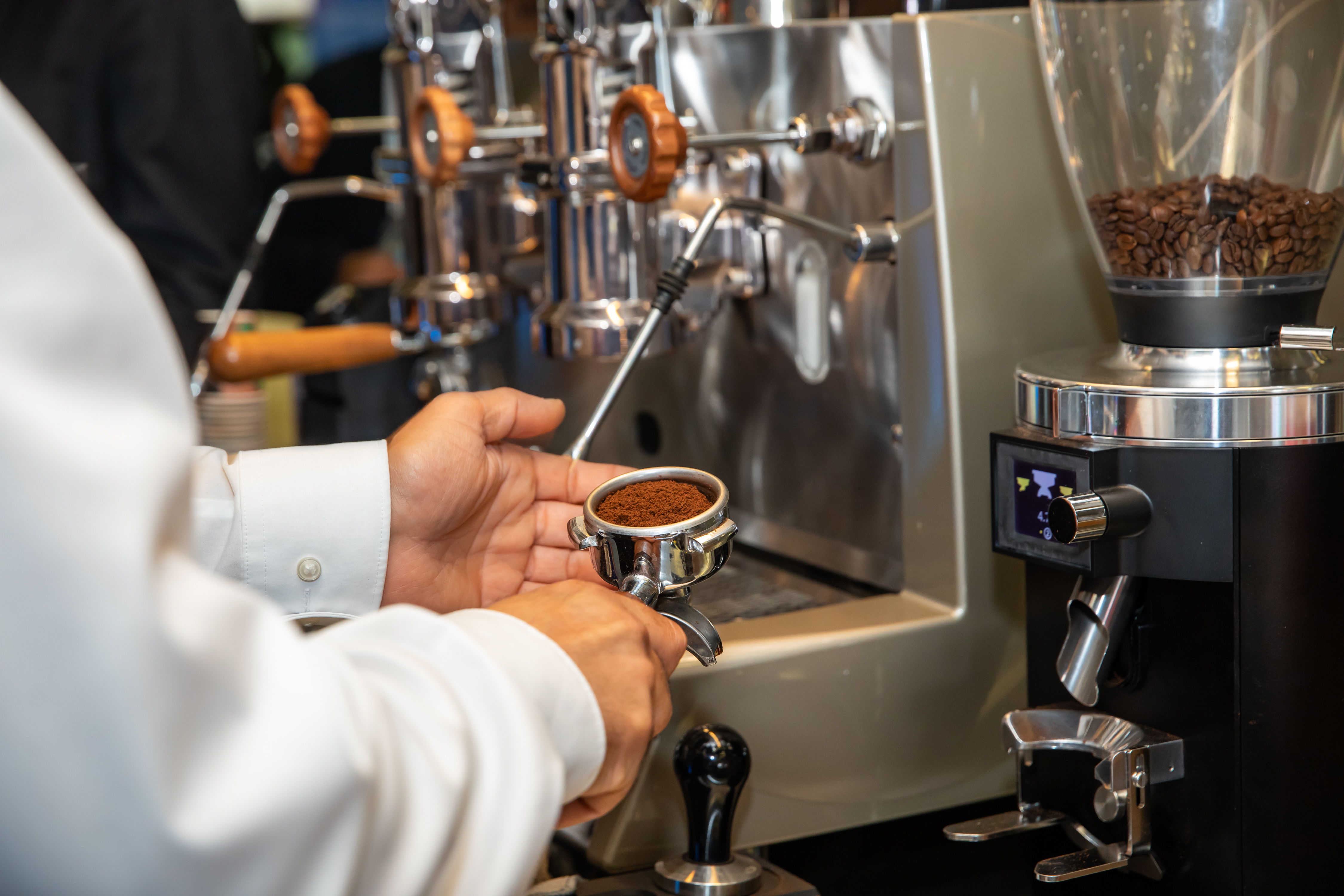 Nahazfnahe von Händen eines Baristas, der gerade einen Kaffee in seinem Coffeee Bike kocht.