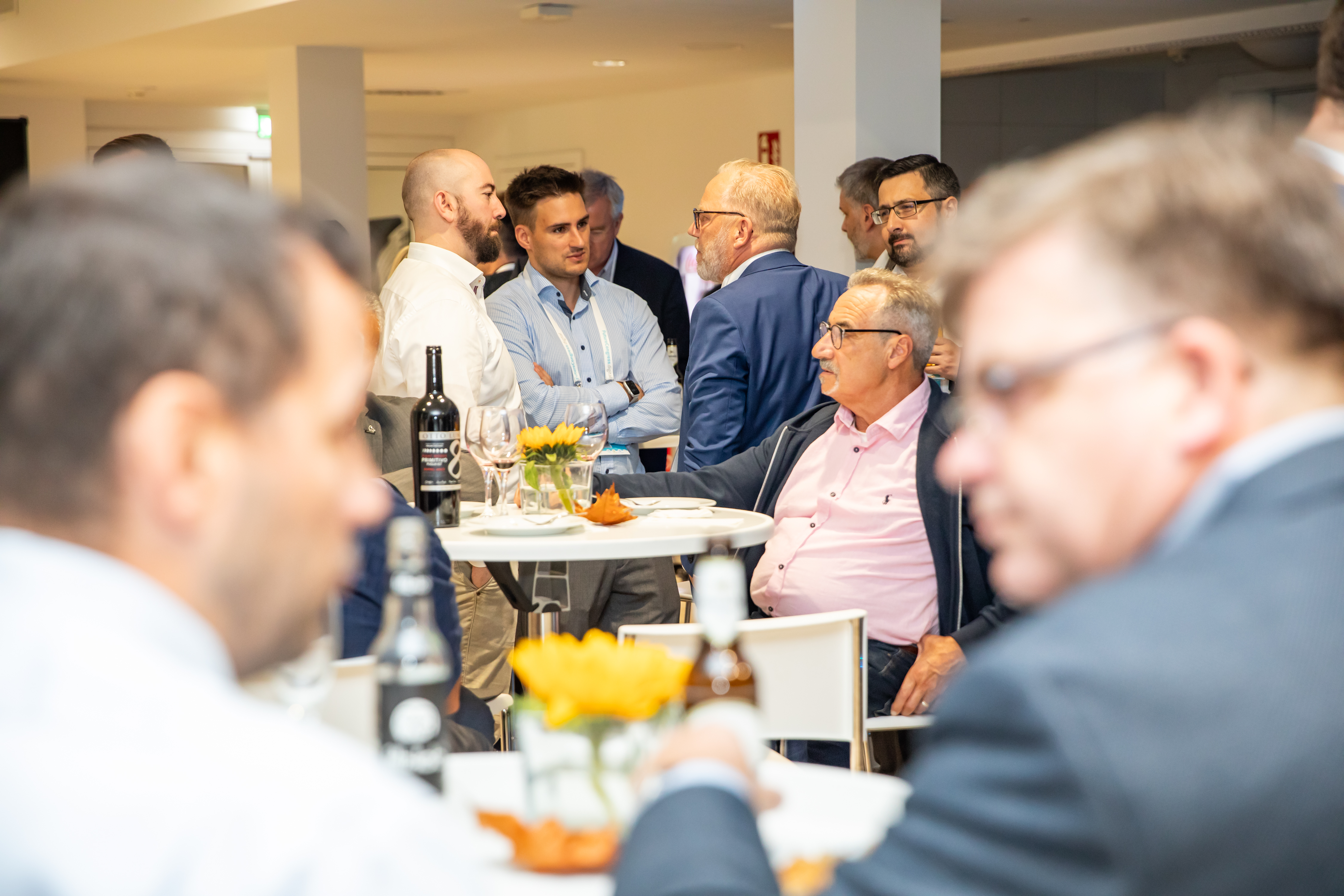Frauen und Männer sitzen und stehen zusammen im Betriebsrestaurant des Wolfsburger Nordkopf Tower und unterhalten sich.